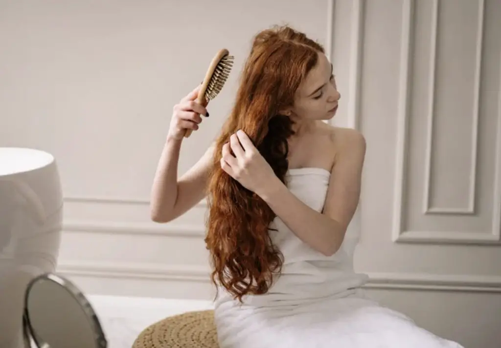 Woman brushing white buildup from scalp